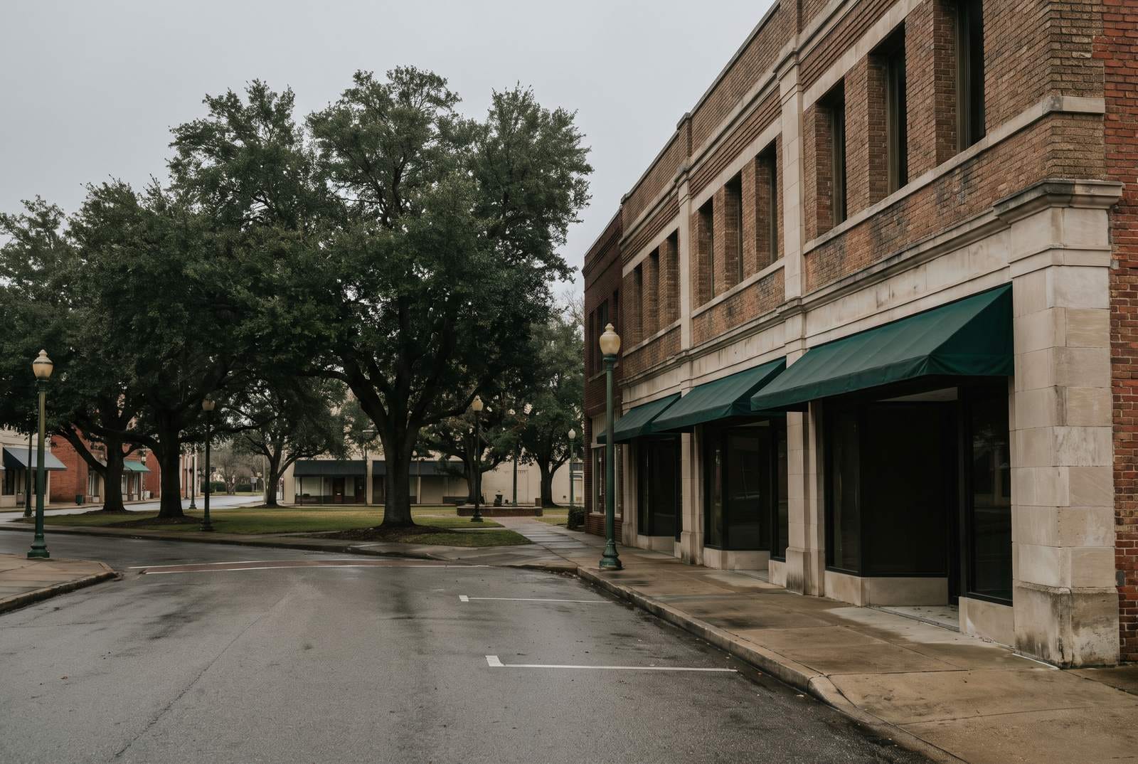 A town square with a central green and a run of two-story brick storefronts