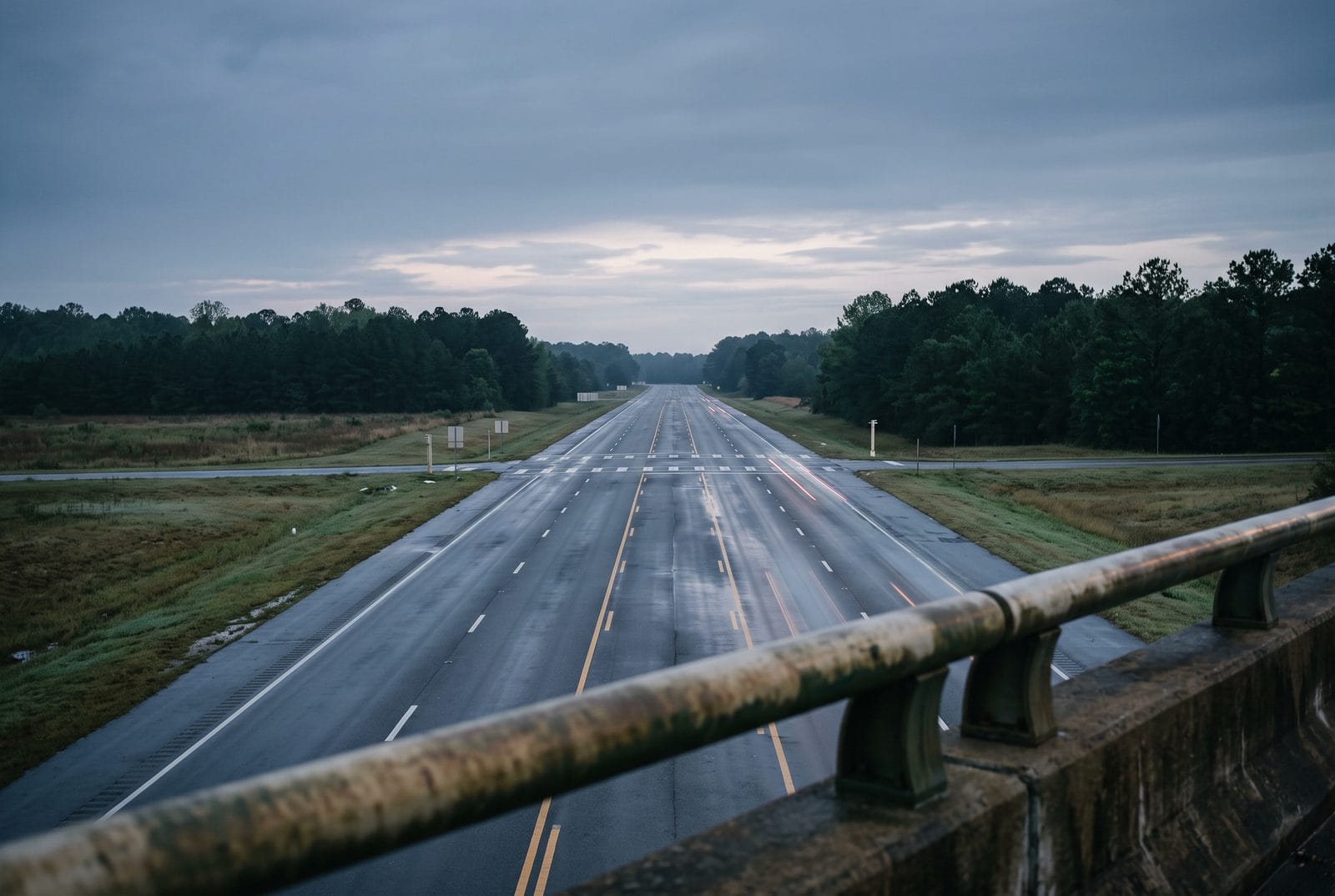 An empty marked crossing on a wide suburban road at dawn